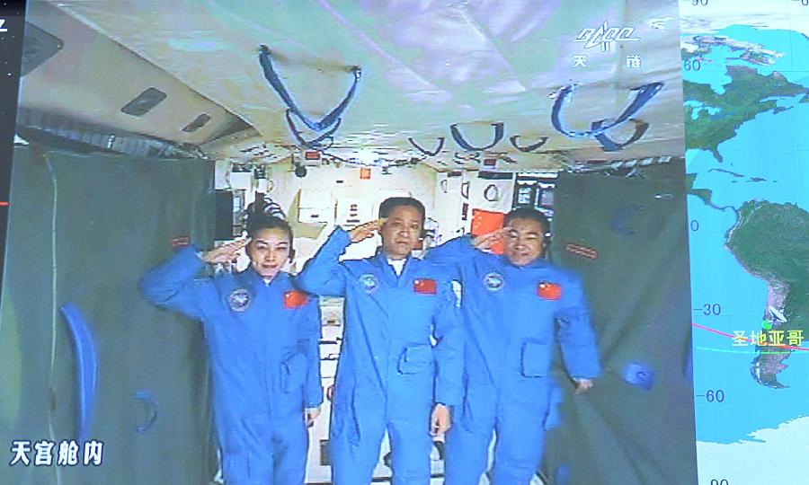 Photo taken on June 24, 2013 shows the screen at the Beijing Aerospace Control Center showing astronauts Nie Haisheng (C), Zhang Xiaoguang (R) and Wang Yaping saluting in Tiangong-1 space lab module. Chinese President Xi Jinping came to the Beijing Aerospace Control Center Monday morning to talk with the astronauts aboard Tiangong-1. (Xinhua/Li Tao)