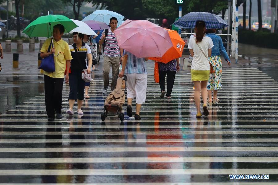 Citizens walk in the rain on the street in Nanjing, capital of east China's Jiangsu Province, June 23, 2013. (Xinhua/Han Hua) 