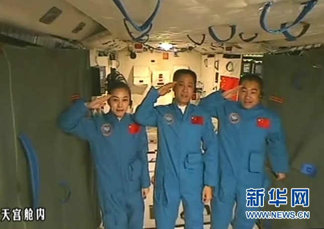 Photo taken on June 24, 2013 shows the screen at the Beijing Aerospace Control Center showing astronauts Nie Haisheng (C), Zhang Xiaoguang (R) and Wang Yaping saluting in Tiangong-1 space lab module. Chinese President Xi Jinping came to the Beijing Aerospace Control Center Monday morning to talk with the astronauts aboard Tiangong-1. (Xinhua)