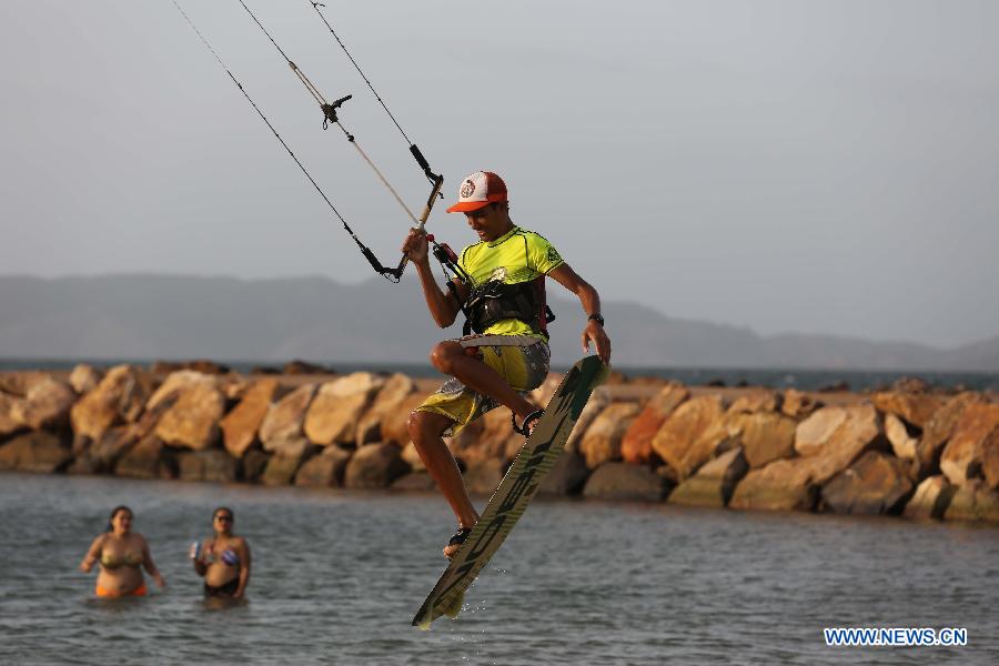 A kite surfer takes to air at Lido Beach in Lecheria City, Venezuela, on June 21, 2013. (Xinhua/Juan Carlos Hernandez)