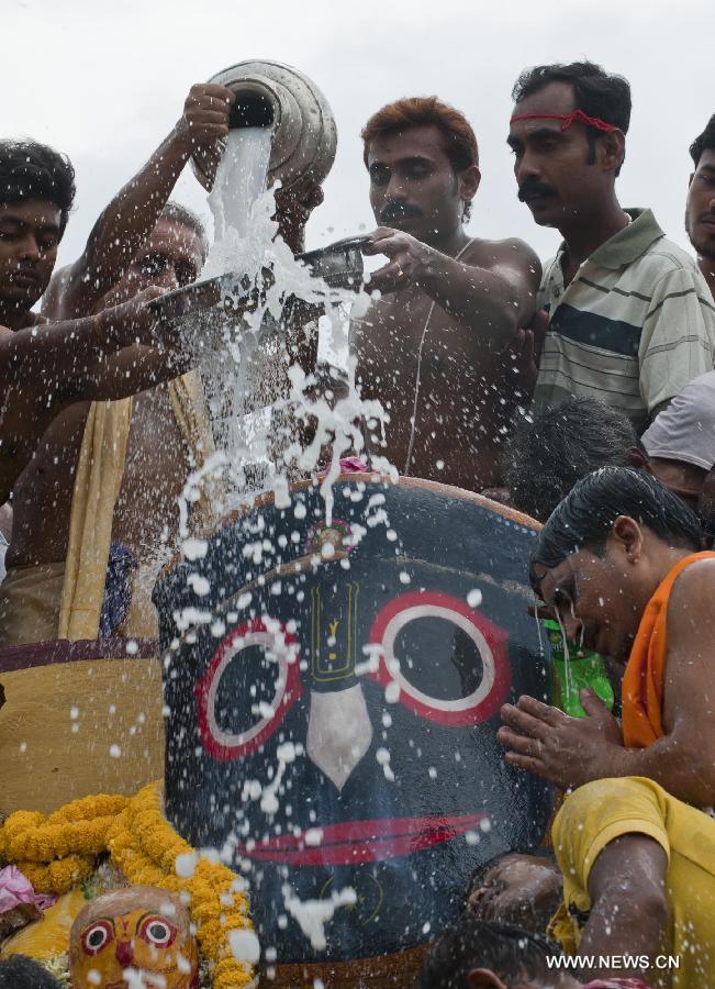 Indian priests pour milk and water during the holy bathing ceremony of Lord Jagannath at a temple near Calcutta, capital of eastern Indian state West Bengal, on June 23, 2013. (Xinhua/Tumpa Mondal) 