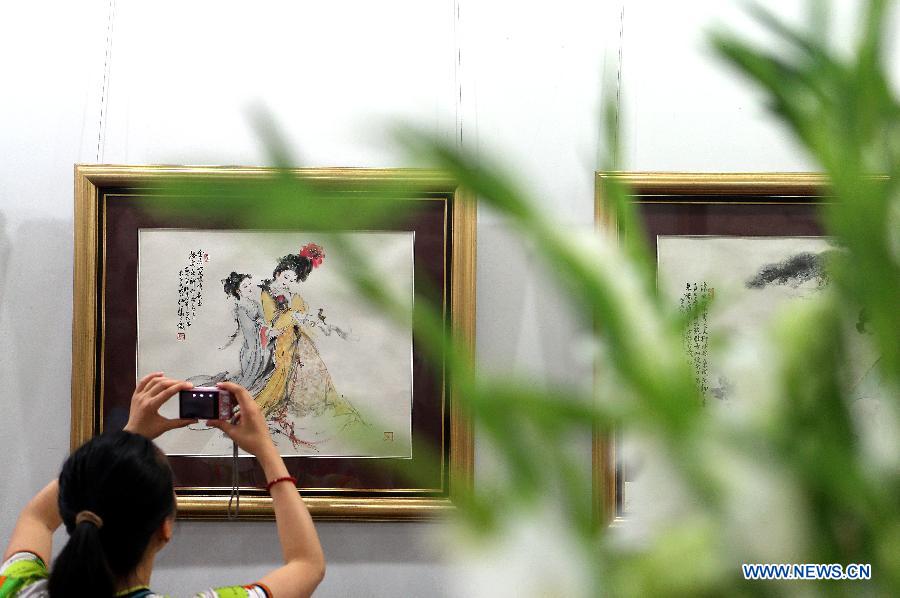 A visitor takes photo of an exhibited painting at a gallery in Beijing, capital of China, June 22, 2013. A total of 40 paintings and calligraphic works created by artist Bai Bohua were exhibited on a gallery show here on June 22. (Xinhua/Zhang Chuanqi)