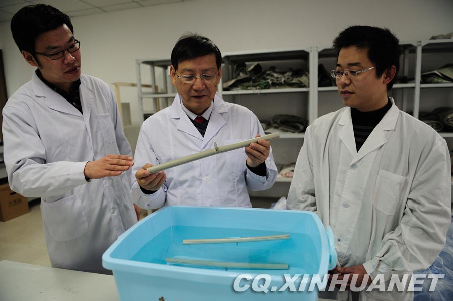 Lyu Changfu demonstrates the method to test the PRP pipe: place a 1 yuan coin in the middle of a 60g PRP pipe and put it into water, eliminate the air of inside pipe, if the pipe sinks to the bottom, it is of inferior quality. (Xinhua/ Huang Junhui) 