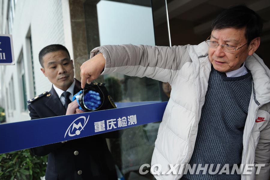 Lyu Changfu demonstrates how to test the quality of the tempered glass. (Xinhua/ Huang Junhui)