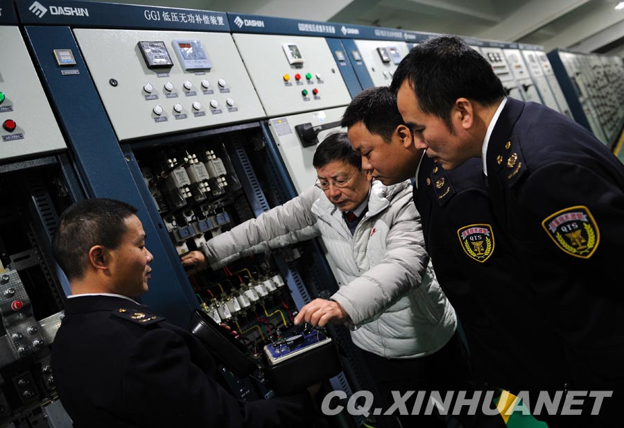 Lyu Changgui introduces how to test the quality of the low voltage switch box. (Xinhua/ Huang Junhui) 