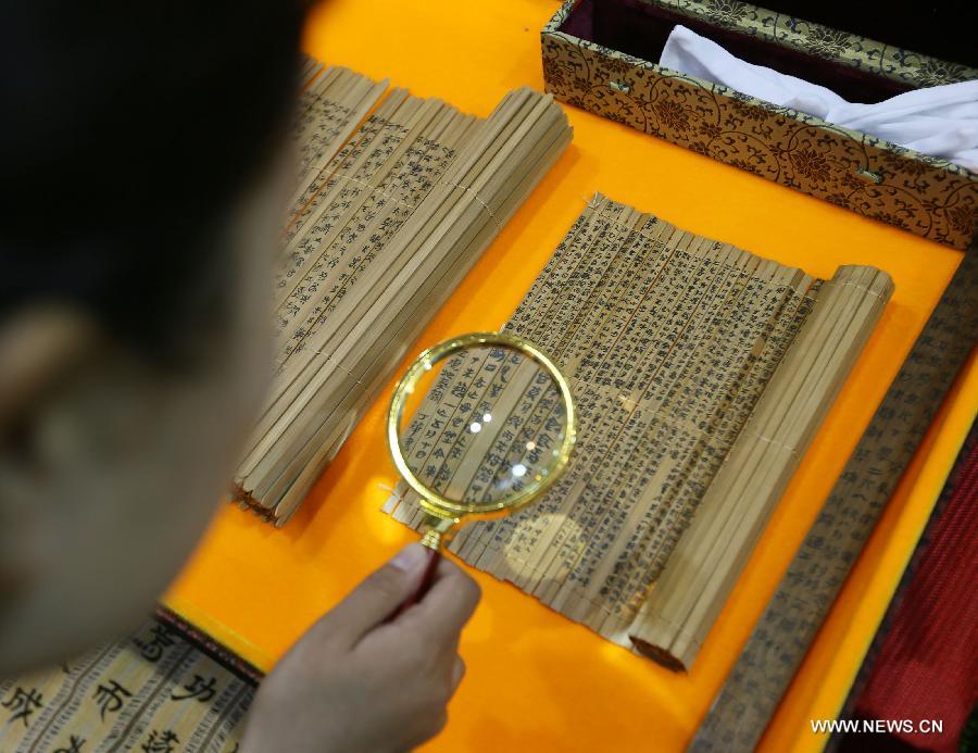 A visitor views bamboo slips (used for writing on in ancient China) at the Luxury China 2013 exhibition in Beijing, capital of China, June 22, 2013. The 3-day exhibition kicked off on Saturday, with over 300 exhibitors participated. (Xinhua)  