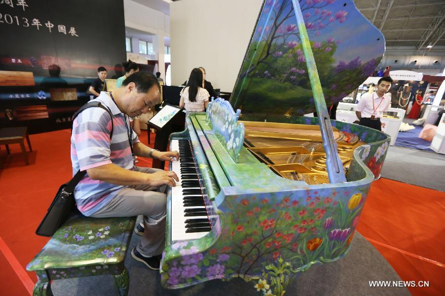 A visitor plays piano at the Luxury China 2013 exhibition in Beijing, capital of China, June 22, 2013. The 3-day exhibition kicked off on Saturday, with over 300 exhibitors participated. (Xinhua) 