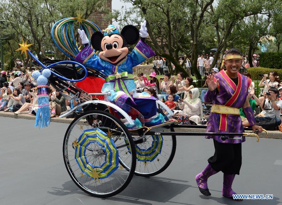 The cartoon character "Mickey Mouse" waves to tourists during a celebration march marking "Tanabata", or the Star Festival, at the Tokyo Disneyland in Urayasu, suburban Tokyo, June 24, 2013. Japanese celebrate the traditional Star Festival on July 7 annually. (Xinhua/Ma Ping)