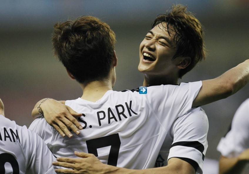 Singer Choi Minho (R) of South Korean K-Pop group SHINee, who is part of the Park Ji-sung and Friends soccer team, celebrates with teammate Park Ji-sung after scoring against the Shanghai Laokele Stars during a charity soccer match at the Shanghai Hongkou Stadium in Shanghai, June 23, 2013. (Chinadaily.com.cn)
