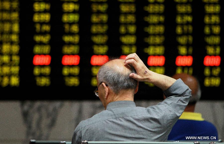 An investor is seen at a trading hall of a securities firm in Shanghai, east China, June 24, 2013. Chinese shares plunged on Monday and closed below a key psychological mark over worries about the liquidity crunch in the financial system and subdued strength in the world's second largest economy. The benchmark Shanghai Composite Index tumbled 5.3 percent to end at 1,963.24, the lowest point in nearly seven months, while the Shenzhen Component Index pummeled 6.73 percent to 7,588.52. (Xinhua/Ding Ting)