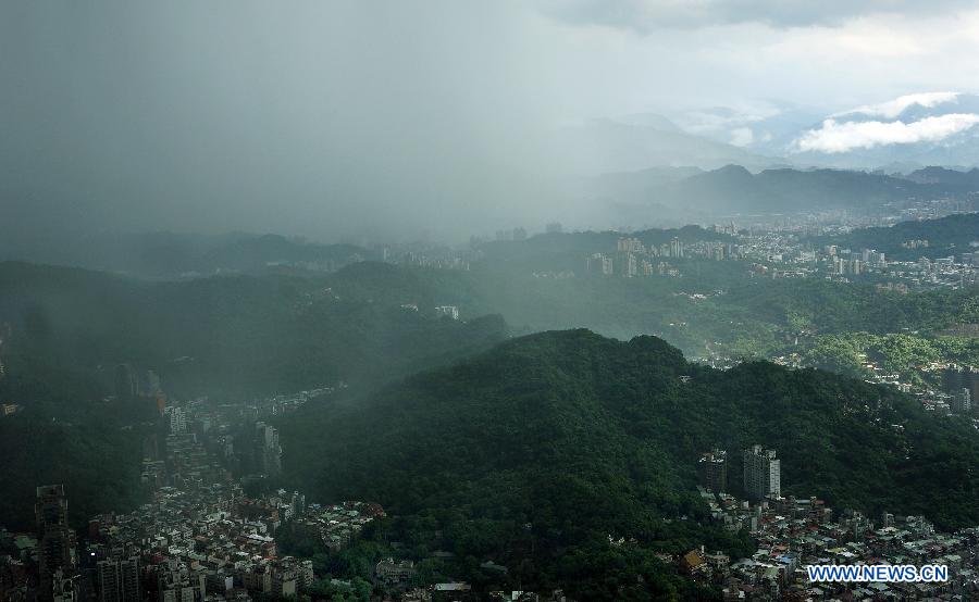 Photo taken on June 24, 2013 shows the western area of Taipei bathed in sunshine while the eastern area hit by rain in Taipei, southeast China's Taiwan. (Xinhua/Tao Ming)
