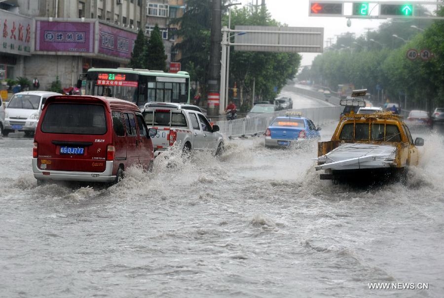 Vehicles run on a flooded street as heavy rainfall hit Tongling of east China's Anhui Province, June 24, 2013. (Xinhua/Guo Shining) 
