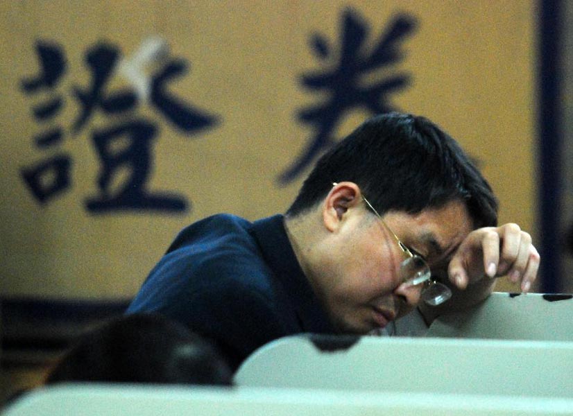 A stock investor worries the stock price at a trading hall of securities firm in Jiangxi on Oct 26, 2012. On that day, Chinese shares slumped, the benchmark Shanghai Composite Index lost 1.68%, or 35.37 points, to end at 2066.21 points. The Shenzhen Component Index fell 2.18%, or 187.96 points, to end at 8414.85 points. (Xinhua/ Hu Guolin) 