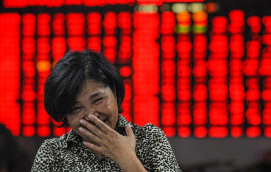 A stock investor smiles at a trading hall of a securities firm in Hangzhou on Oct. 9, 2012. On that day Chinese shares jumped up. The benchmark Shanghai Composite Index increased 1.97 percent to close at 2,115.23 points. The Shenzhen Component Index rose 3.75 percent to close at 8,743.86 points. (File Photo) 