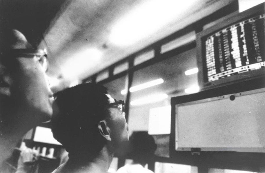 Shanghai stock investor observes stock price on July 17, 1995. After weeks of consolidation, Shanghai stock market rose finally on the day closing at 695 points, and transaction value reached 2.5 billion yuan. (Xinhua/Zhang Ming) 