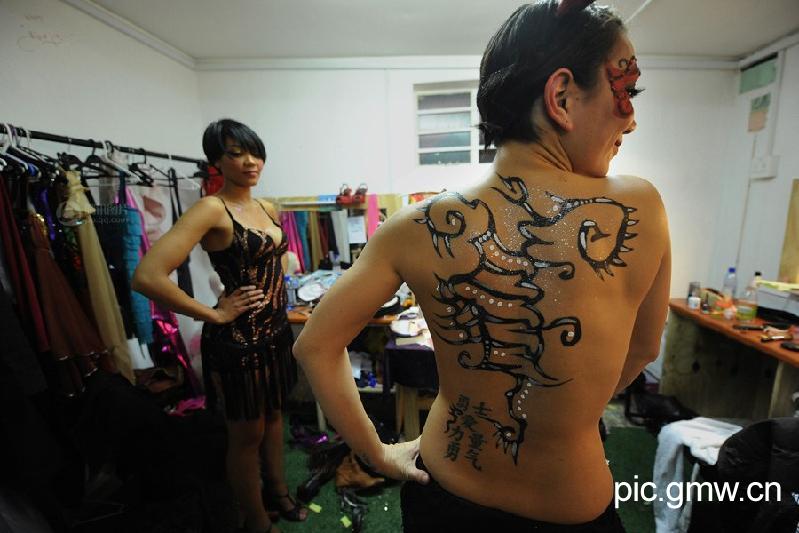 Chinese character tattoo on a girl's waist "Warriors, love, strength and courage." In the dressing room, dancers always wear sexy dresses. (Photo/GMW)