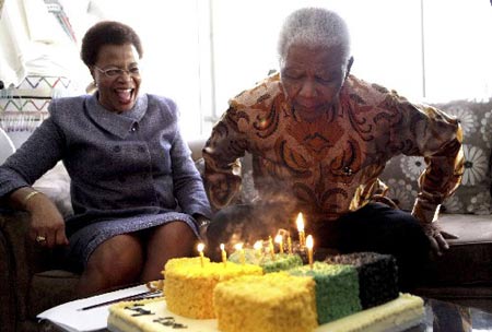 South Africa Former President Nelson Mandela blows out candles next to his wife Graca Machel on his 91st birthday at his home in Johannesburg July 18, 2009. (Xinhua/AFP Photo)