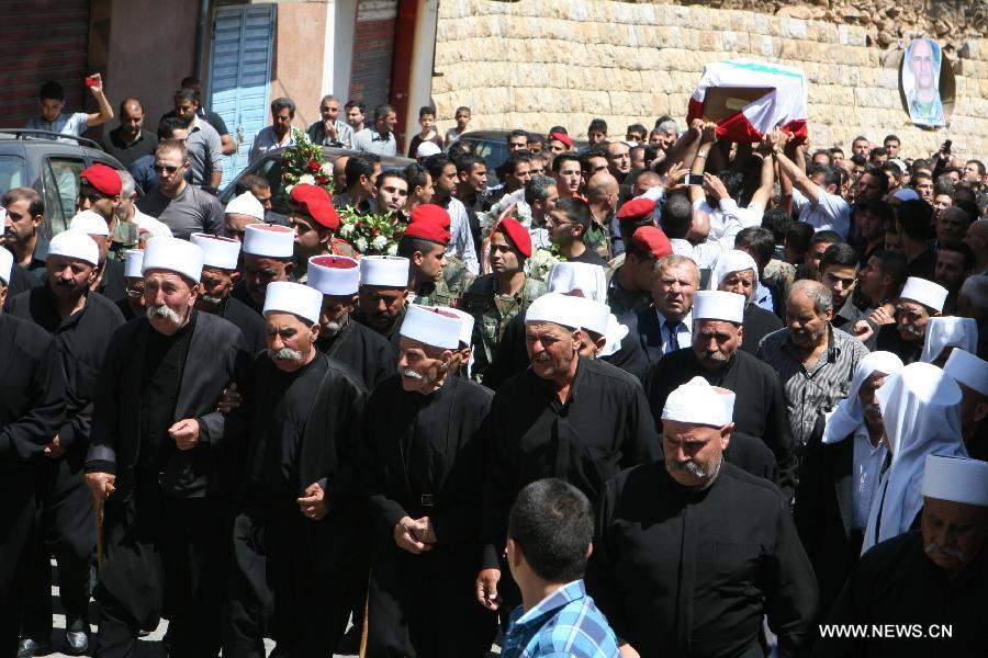 Mourners take part in the funeral of a Lebanese soldier, who was killed during clashes between the Lebanese army and Sunni radicals, in the country's southern town of Rmeish on June 24, 2013. Twelve soldiers were killed and 50 others injured on Monday when Lebanese army was trying to arrest Salafist cleric Sheikh Ahmed Al Assir in the southern city of Sidon. (Xinhua) 
