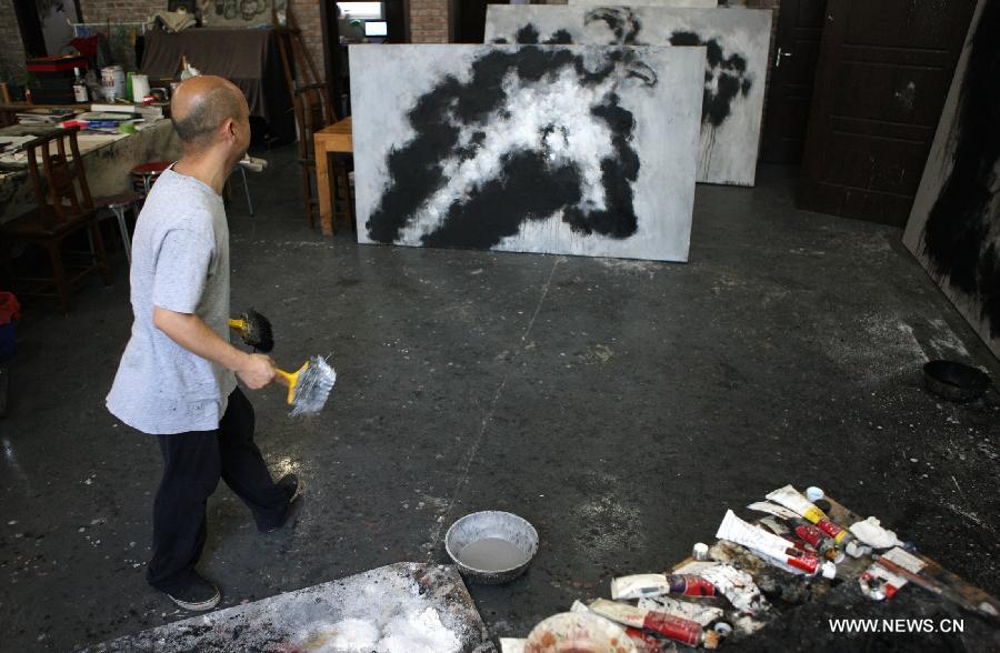 Zhang Fangbai, a 51-year-old painter, draws a picture at his studio in Beijing, capital of China, June 19, 2013. Zhang has specialized in painting eagles for a dozen of years. (Xinhua/Wu Xiaochu) 
