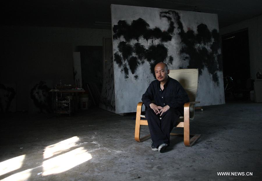 Zhang Fangbai, a 51-year-old painter, sits at his studio in Beijing, capital of China, June 19, 2013. Zhang has specialized in painting eagles for a dozen of years. (Xinhua/Wu Xiaochu)