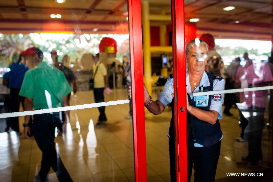 A staff closes an exit to the flight SU150 from Moscow, Russia, due to the emergency of too many journalists at the Jose Marti airport in Havana, Cuba, June 24, 2013. Former U.S. intelligence contractor Edward Snowden did not show up at the flight. (Xinhua/Liu Bin)