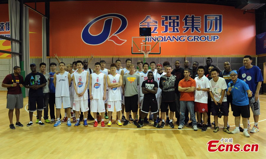 NBA players take photos with Chinese basketball players on a basketball court at the Jin Qiang national basketball training base in Chengdu, Southwest China's Sichuan Province, June 24, 2013. NBA stars visited Chengdu and played a game against China's August 1 Men's Basketball Team on Monday. (CNS/Liu Zhongjun)