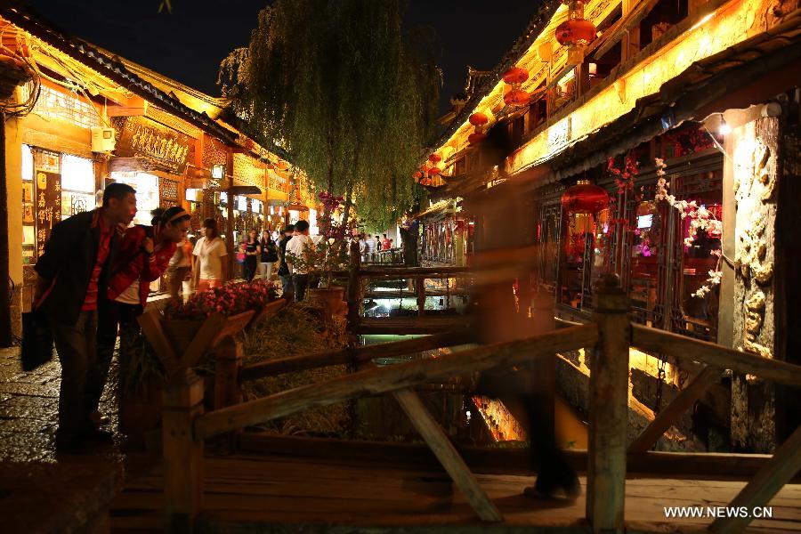 Tourists visit the Old Town of Lijiang, southwest China's Yunnan Province, June 23, 2013. Lijiang has entered the peak tourism season with the coming of the summer. (Xinhua/Liang Zhiqiang)