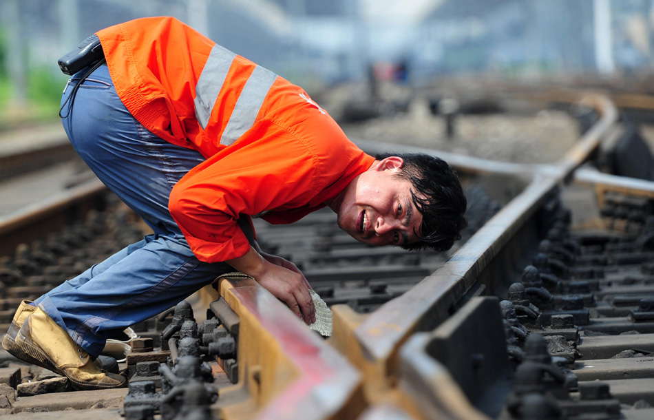 A technician examines the railway despite of the temperature of 42 degrees Celsius in Jiujiang, Jiangxi province. (Photo by Hu Guolin/ Xinhua)