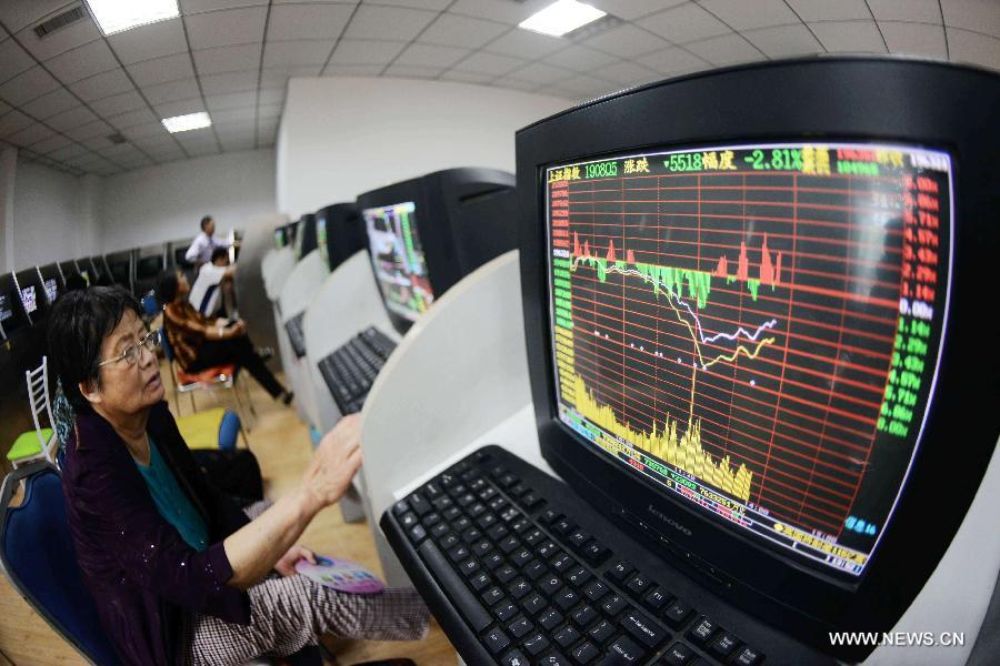 An investor looks at the stock information at a trading hall of a securities firm in Qingdao, east China's Shandong Province, June 25, 2013. Chinese shares extended losses on Tuesday following Monday's drastic slump as the benchmark Shanghai Composite Index lost 0.19 percent, or 3.73 points, to end at 1,959.51, the lowest point in nearly seven months. The Shenzhen Component Index shrank 1.23 percent, or 93.43 points, to 7,495.10. (Xinhua) 