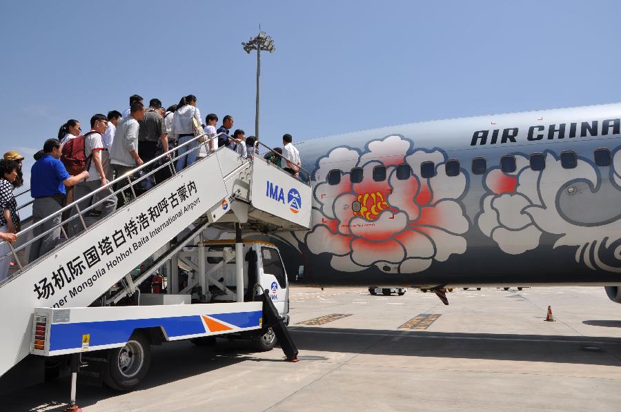 Passengers board an airplane to leave for Taipei, southeast China's Taiwan, in Hohhot, capital of north China's Inner Mongolia Autonomous Region, June 25, 2013. Air China opened the direct flight from Hohhot to Taipei on Tuesday. (Xinhua/Yu Jia)