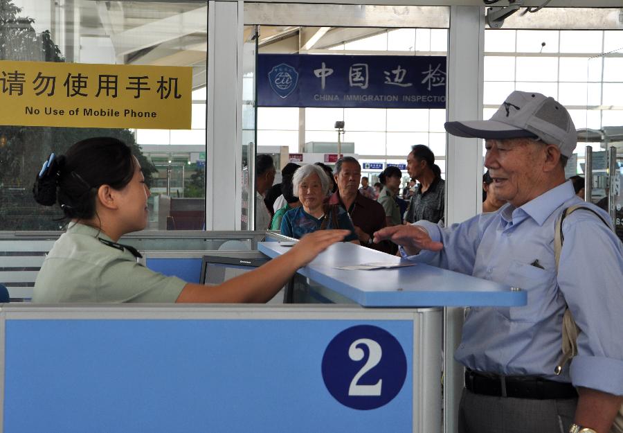 Passengers check in before boarding an airplane to leave for Taipei, southeast China's Taiwan, in Hohhot, capital of north China's Inner Mongolia Autonomous Region, June 25, 2013. Air China opened the direct flight from Hohhot to Taipei on Tuesday. (Xinhua/Yu Jia)