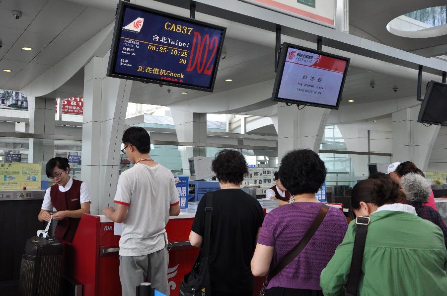 Passengers check in before boarding an airplane to leave for Taipei, southeast China's Taiwan, in Hohhot, capital of north China's Inner Mongolia Autonomous Region, June 25, 2013. Air China opened the direct flight from Hohhot to Taipei on Tuesday. (Xinhua/Yu Jia)