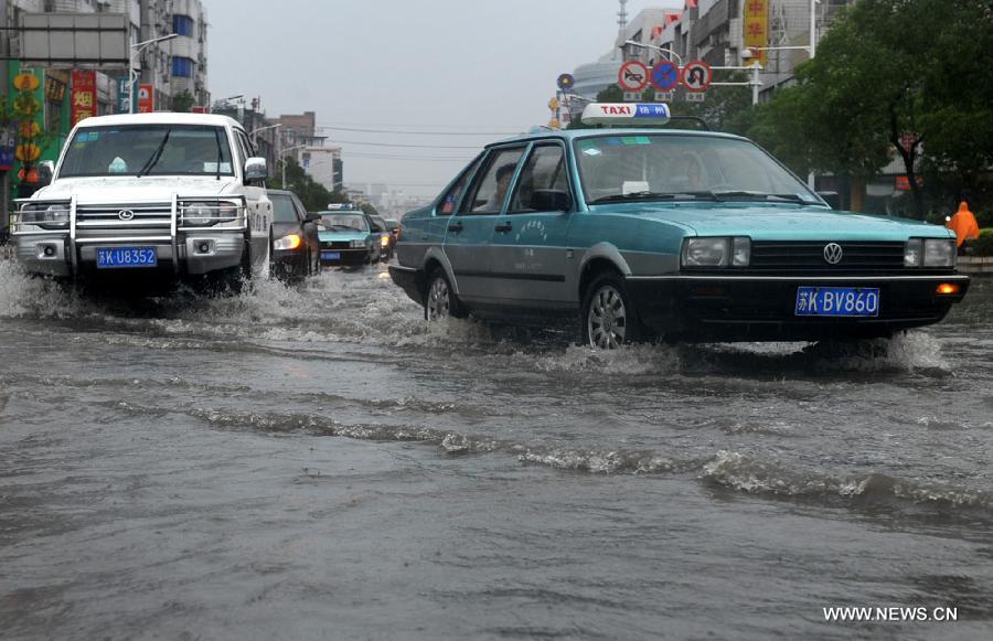 Cars move on the waterlogged road in Yangzhou City, east China's Jiangsu Province, June 25, 2013. Heavy rainfall hit many parts of Jiangsu on Tuesday. (Xinhua)