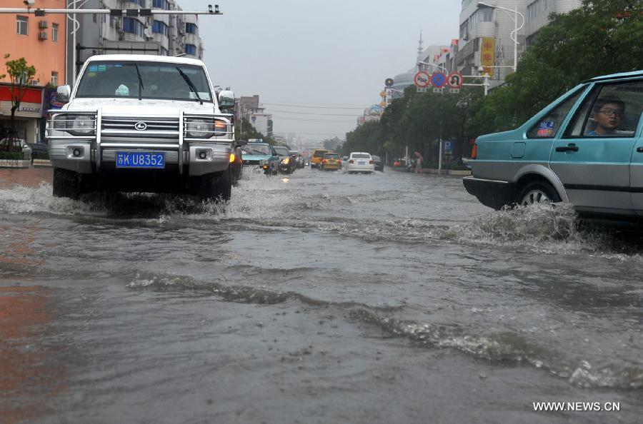Cars move on the waterlogged road in Yangzhou City, east China's Jiangsu Province, June 25, 2013. Heavy rainfall hit many parts of Jiangsu on Tuesday. (Xinhua)