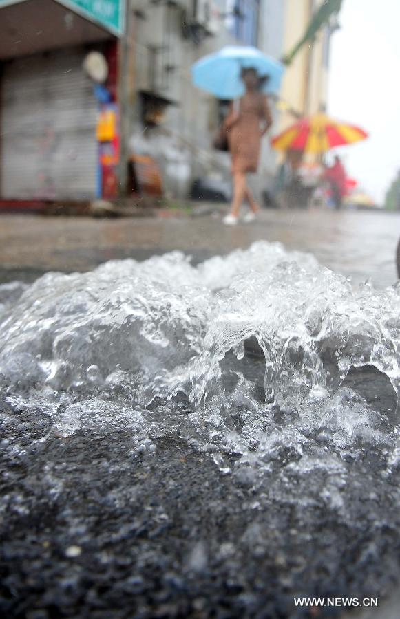 Citizens walk in the rain in Yangzhou City, east China's Jiangsu Province, June 25, 2013. Heavy rainfall hit many parts of Jiangsu on Tuesday. (Xinhua/Yang Yue)