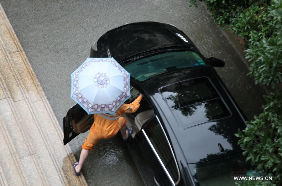 A citizen prepares to drive a car on a waterlogged road in Nanjing City, capital of east China's Jiangsu Province, June 25, 2013. Heavy rainfall hit many parts of Jiangsu on Tuesday. (Xinhua)