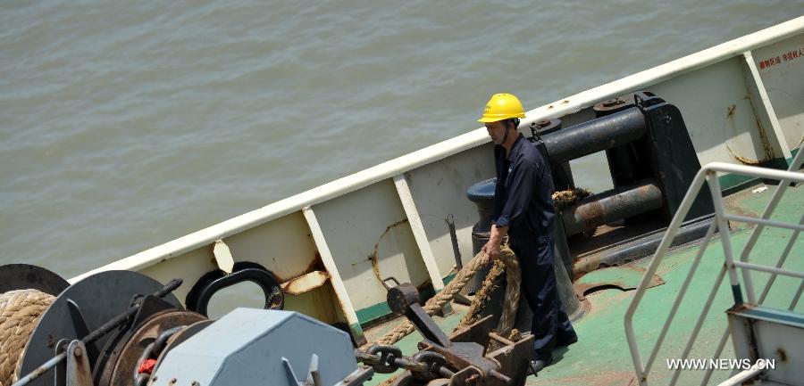 A seaman works on the "Xinhai No. 19" ro-ro passenger ship which ferries in the Qiongzhou Strait in south China's Hainan Province, June 25, 2013. June 25 marks the third International Day of the Seafarer. (Xinhua/Zhao Yingquan)