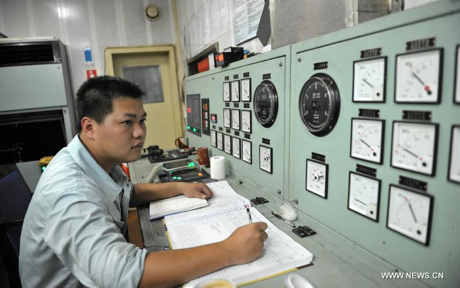 A seaman on the "Xinhai No. 19" ro-ro passenger ship which ferries along the Qiongzhou Strait checks marine engine data in the engine room of the ship in south China's Hainan Province, June 25, 2013. June 25 marks the third International Day of the Seafarer. (Xinhua/Zhao Yingquan)
