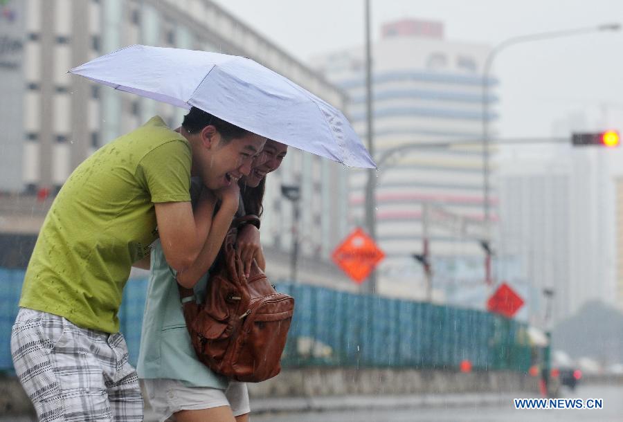 People walk in the rain in Singapore, on June 25, 2013. A sudden downpour relieved the smoke haze caused by forest fires in neighboring Indonesia in Singapore on Tuesday afternoon. (Xinhua/Then Chih Wey)