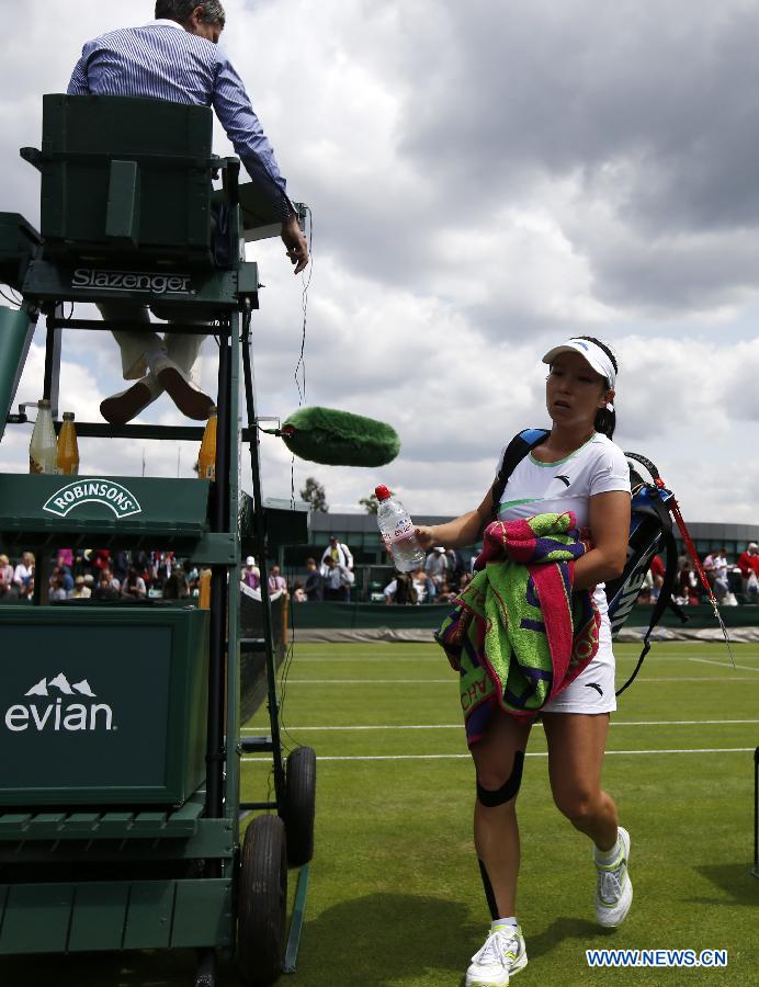 Zheng Jie of China leaves the court after the first round of ladies' singles against Caroline Garcia of France on day 2 of the Wimbledon Lawn Tennis Championships at the All England Lawn Tennis and Croquet Club in London, Britain on June 25, 2013. Zheng lost 0-2. (Xinhua/Wang Lili)