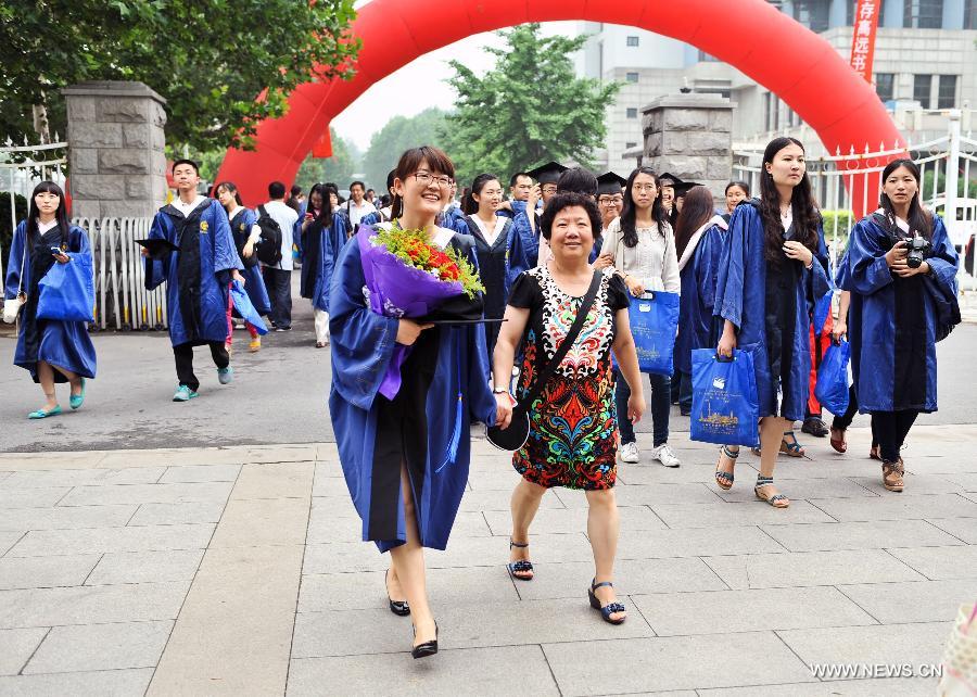 Students for the 2013 Graduation Ceremony walk on campus with families in the Capital Normal University in Beijing, capital of China, June 25, 2013. (Xinhua/Li He) 