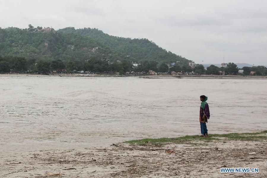 A woman stands by the Ganges River in Haridwar, northern Indian state of Uttarakhand, June 25, 2013. The heaviest monsoon rains in the state for the past 60 years, which trigered deadly floods in northern India, has claimed up to 807 lives, according to Indian Authorities on Tuesday. (Xinhua/Zheng Huansong) 