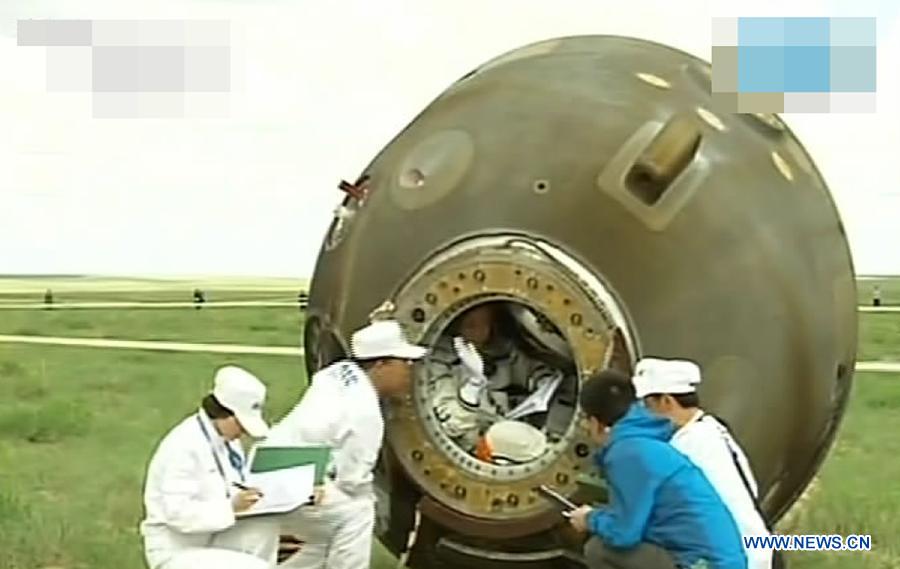 The screenshot shows the three astronauts having prepared to go out of the re-entry capsule of China's Shenzhou-10 spacecraft after its successful landing at the main landing site in north China's Inner Mongolia Autonomous Region on June 26, 2013. (Xinhua)