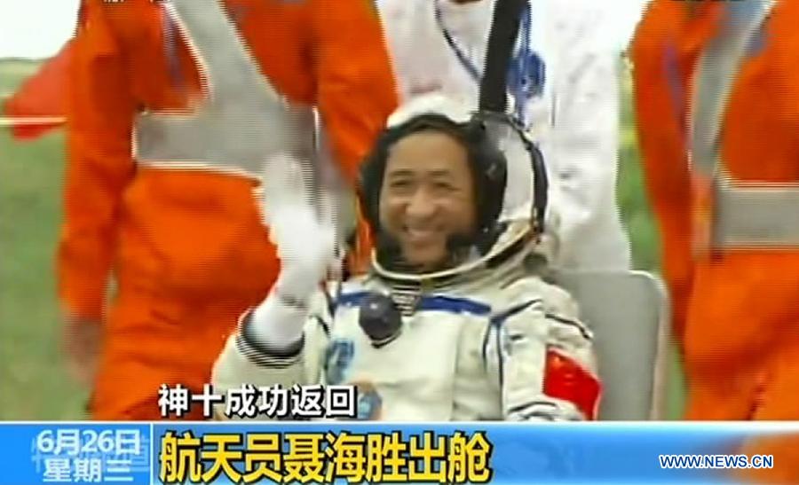 The screenshot shows astronaut Nie Haisheng going out of the re-entry capsule of China's Shenzhou-10 spacecraft after its successful landing at the main landing site in north China's Inner Mongolia Autonomous Region on June 26, 2013. (Xinhua) 