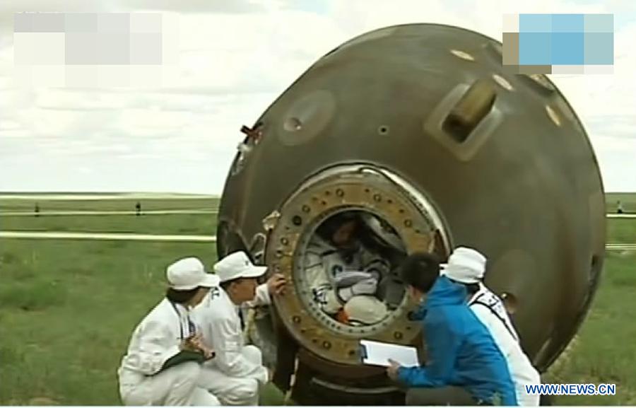 The screenshot shows the three astronauts having prepared to go out of the re-entry capsule of China's Shenzhou-10 spacecraft after its successful landing at the main landing site in north China's Inner Mongolia Autonomous Region on June 26, 2013. (Xinhua)