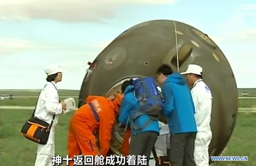 Video grab shows the working staff opening the re-entry capsule of China's Shenzhou-10 spacecraft after its successful landing at the main landing site in north China's Inner Mongolia Autonomous Region on June 26, 2013. (Xinhua)
