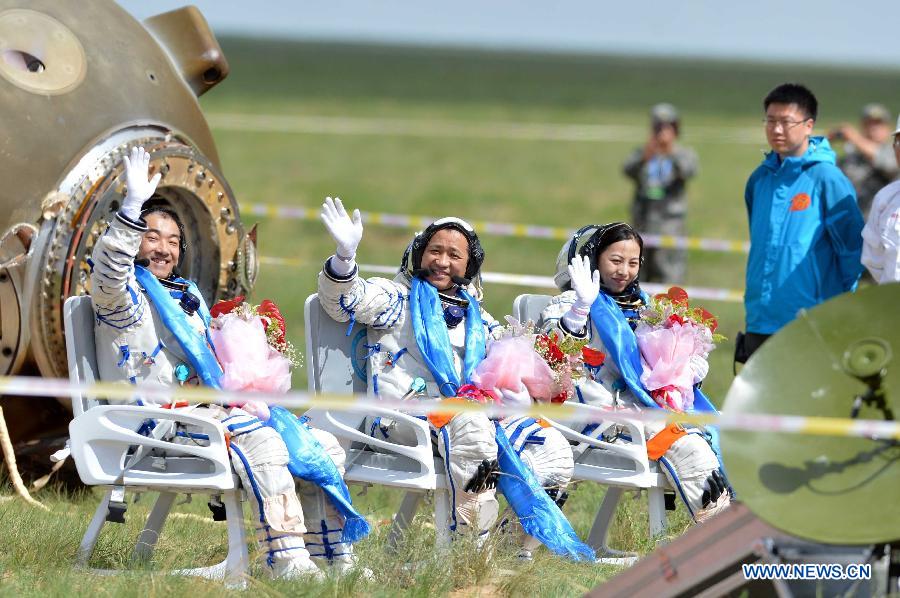 Astronauts Zhang Xiaoguang, Nie Haisheng and Wang Yaping (from left to right) wave after getting out of the re-entry capsule of China's Shenzhou-10 spacecraft following its successful landing at the main landing site in north China's Inner Mongolia Autonomous Region on June 26, 2013. (Xinhua/Ren Junchuan)