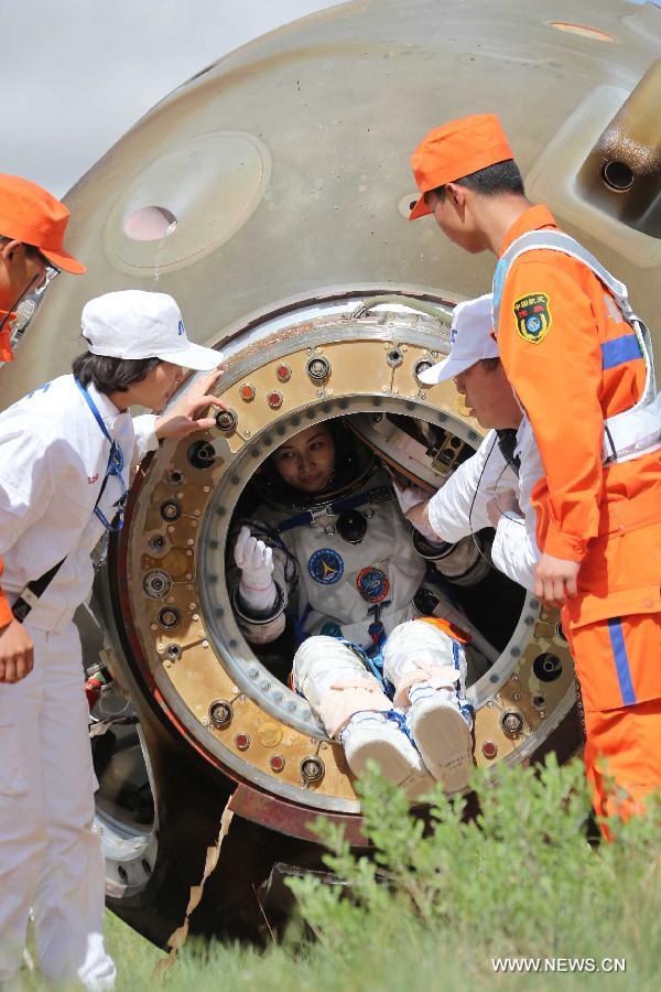 Astronaut Wang Yaping goes out of the re-entry capsule of China's Shenzhou-10 spacecraft following its successful landing at the main landing site in north China's Inner Mongolia Autonomous Region on June 26, 2013. (Xinhua/Wang Jianmin)