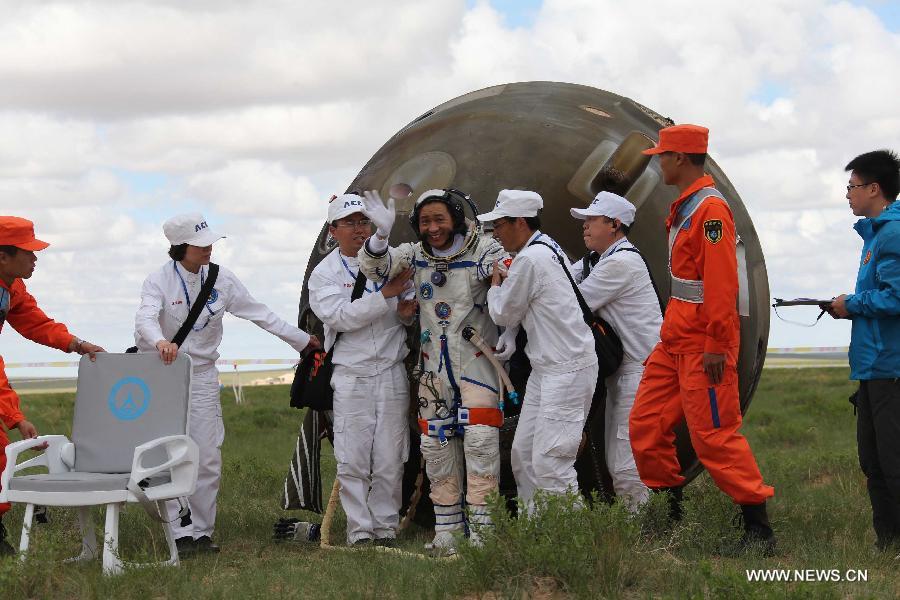 Astronaut Nie Haisheng goes out of the re-entry capsule of China's Shenzhou-10 spacecraft following its successful landing at the main landing site in north China's Inner Mongolia Autonomous Region on June 26, 2013. (Xinhua/Wang Jianmin)