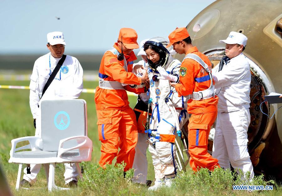 Astronaut Wang Yaping (C) goes out of the re-entry capsule of China's Shenzhou-10 spacecraft after its successful landing at the main landing site in north China's Inner Mongolia Autonomous Region on June 26, 2013. (Xinhua/Zhang Ling) 